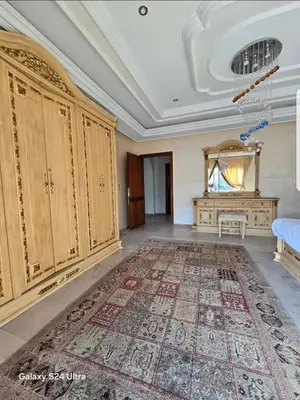 a living room with a large rug and wooden cabinets at Villa de vacances à Hay Riad in Rabat