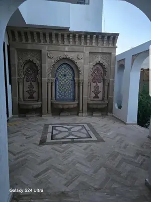 an entrance to a building with a gate and a tile courtyard at Villa de vacances à Hay Riad in Rabat
