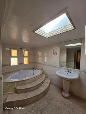 a bathroom with a tub and a sink and a skylight at Villa de vacances à Hay Riad in Rabat