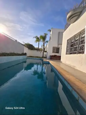 a swimming pool in front of a building at Villa de vacances à Hay Riad in Rabat