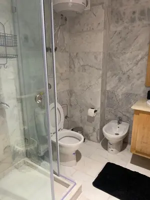 a bathroom with a shower and a toilet and a sink at Appartement de luxe avec vue sur mer in Bouznika