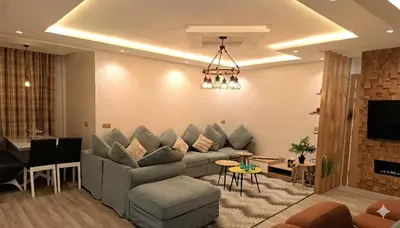 a living room with a couch and a tv at Residence Luxueuse avec 2 Piscines à Harhoura Temara proximité plages princesses & Sables d'Or in El Harhoura