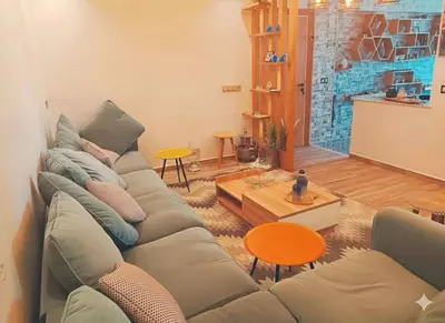 a living room with a couch and a table at Residence Luxueuse avec 2 Piscines à Harhoura Temara proximité plages princesses & Sables d'Or in El Harhoura