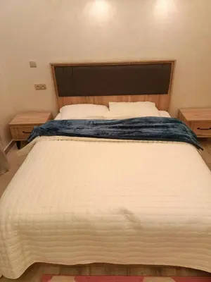 a large white bed with a wooden headboard in a bedroom at Residence Luxueuse avec 2 Piscines à Harhoura Temara proximité plages princesses & Sables d'Or in El Harhoura