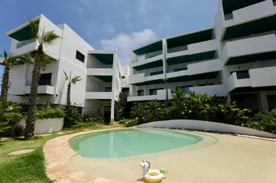 a swimming pool in front of a building at Magnifique appartement front mer in Tamaris