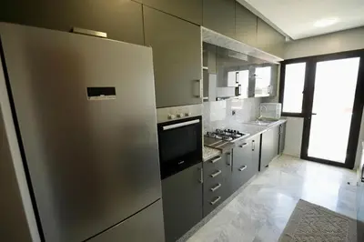 a kitchen with stainless steel appliances and a large window at Magnifique appartement front mer in Tamaris