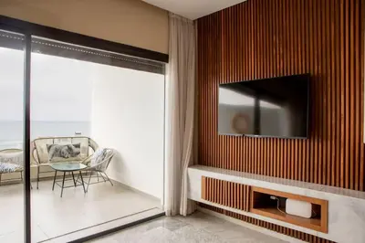a living room with a television on a wall at Magnifique appartement front mer in Tamaris