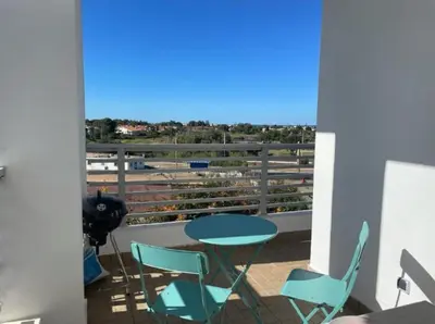a balcony with a table and chairs and a view at Grand appartement vue golf a 2 min de la plage Bouznika in Bouznika