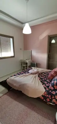 a bedroom with a bed and a window and a table at Grand appartement vue golf a 2 min de la plage Bouznika in Bouznika