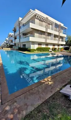 a swimming pool in front of a building at heaven beach sidi rehal in Sidi Rahal