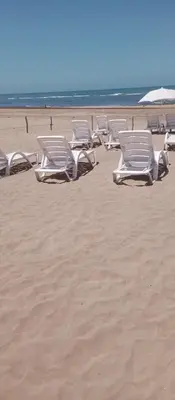 a row of white lounge chairs on a beach at heaven beach sidi rehal in Sidi Rahal