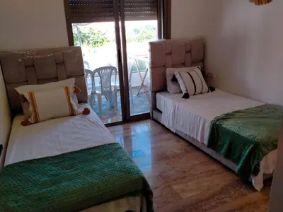 a bedroom with two beds and a balcony at heaven beach sidi rehal in Sidi Rahal