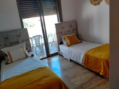 a bedroom with two beds and a balcony at heaven beach sidi rehal in Sidi Rahal