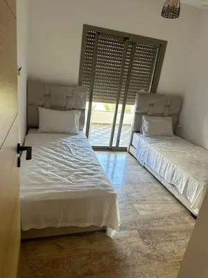 two beds in a room with a window at heaven beach sidi rehal in Sidi Rahal