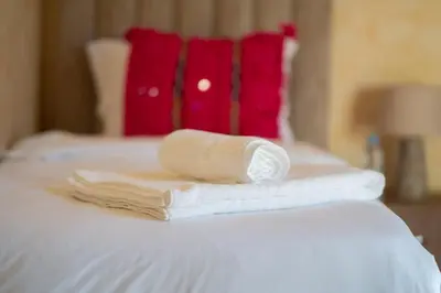 a pile of towels sitting on top of a bed at Maison avec Piscine Proche Plage in El Harhoura