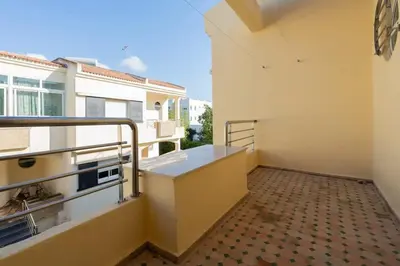 a balcony of a building with a railing and a floor at Maison avec Piscine Proche Plage in El Harhoura