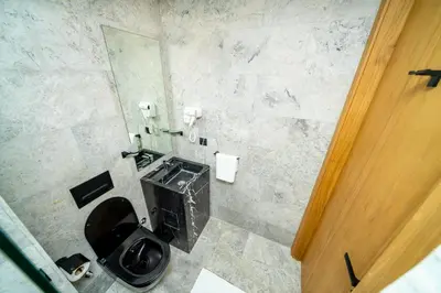 a bathroom with a toilet with a black seat at Twenty Four Inn 304 in Casablanca