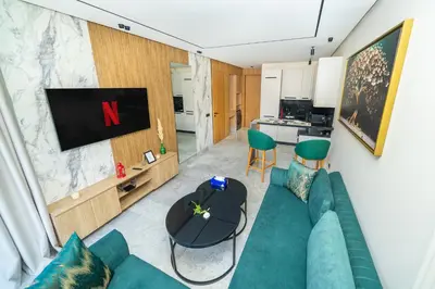 a living room with a green couch and a tv at Twenty Four Inn 304 in Casablanca