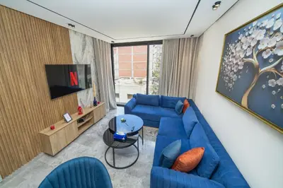 a living room with blue couches and a tv at Twenty Four Inn 303 in Casablanca