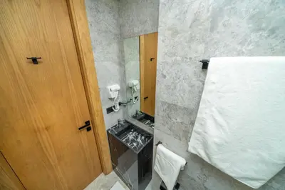 a bathroom with a wooden door and a mirror at Twenty Four Inn 305 in Casablanca