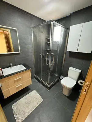 a bathroom with a shower and a toilet and a sink at Cozy New Apartment in Tamaris in Dar Bouazza