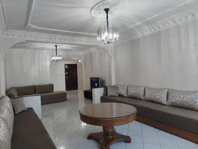 a living room with couches and a table in a room at Appartement de standing in Casablanca