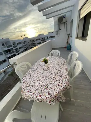 a table and chairs on a balcony with a table at Bel Appartement à mimosa mohammedia in Mohammedia