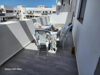 a table and chairs on top of a balcony at Bel Appartement à mimosa mohammedia in Mohammedia