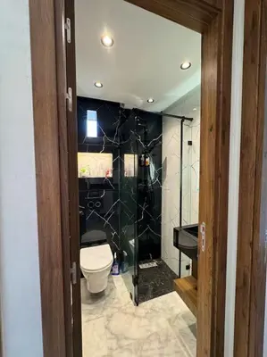 a bathroom with a toilet and a glass door at Studio meublé neuf Maarif au centre de Casablanca 3 minutes de stade Mohamed V in Casablanca