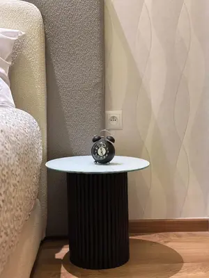 a table with an alarm clock on it next to a bed at Chic Family Place - by AppartAli in Casablanca