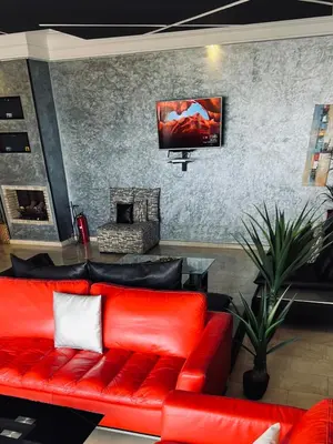 a living room with a red couch and a tv at Ocean Apartments in Casablanca