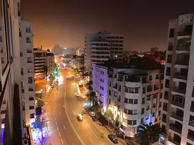 a city street at night with cars and buildings at Elegant appartement de 2 chambres sur bd Anfa in Casablanca