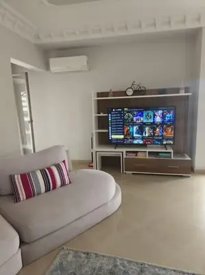 a living room with a couch and a flat screen tv at Elegant appartement de 2 chambres sur bd Anfa in Casablanca