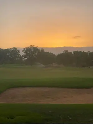a view of a golf course with a sunset in the background at Appartement de Luxe à Bahia Golf Beach Spacieux de 126 m in Bouznika