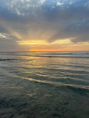 a view of the ocean with the sun setting at Appartement de Luxe à Bahia Golf Beach Spacieux de 126 m in Bouznika