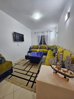 a living room with a couch and a table at Appartement charmant à 5 min de la plage in Skhirat