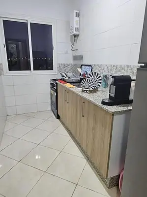 a kitchen with a stove and a counter top at Appartement charmant à 5 min de la plage in Skhirat