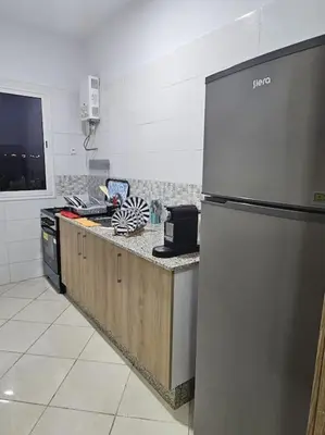 a kitchen with a refrigerator and a counter top at Appartement charmant à 5 min de la plage in Skhirat