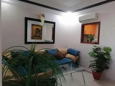 a living room with a blue couch and a mirror at Studio Avenue de France in Rabat