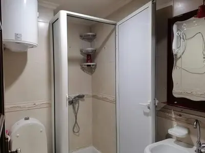 a bathroom with a toilet and a glass shower stall at Studio Avenue de France in Rabat