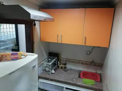 a kitchen with orange cabinets and a white refrigerator at Studio Avenue de France in Rabat