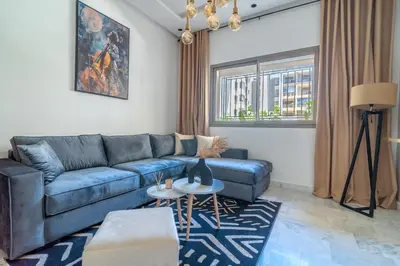a living room with a blue couch and a table at AeroStay in Nouaceur