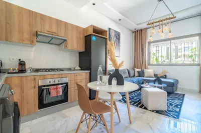 a kitchen and living room with a table and a couch at AeroStay in Nouaceur