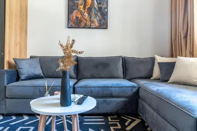 a living room with a blue couch and a table at AeroStay in Nouaceur