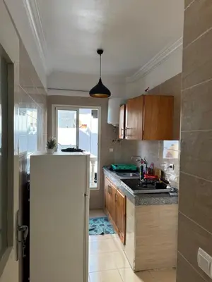 a kitchen with a sink and a refrigerator at Garsoniere Borj in Rabat