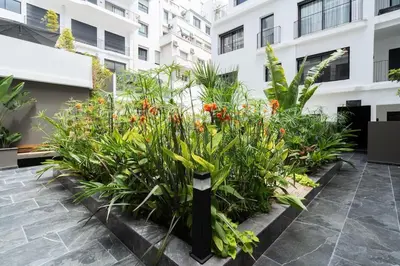 a garden with flowers and plants in front of a building at Superbe appartement à Casablanca in Casablanca