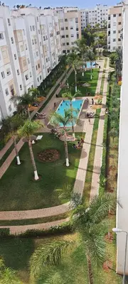 an aerial view of a park with palm trees and buildings at Cozy appt in Casablanca