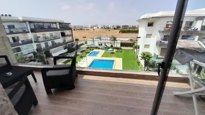 a balcony with a view of a pool and buildings at Rayyan Appartement in Bouznika