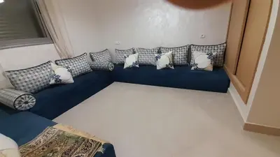 a blue couch with pillows on it in a room at Rayyan Appartement in Bouznika