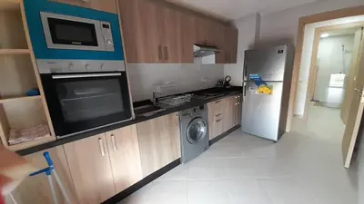 a kitchen with a refrigerator and a stove and a microwave at Rayyan Appartement in Bouznika